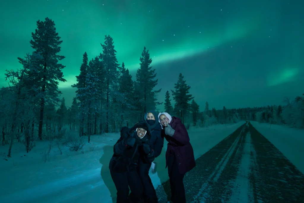 Northern lights aurora borealis over a snowy road in Levi, Finnish Lapland