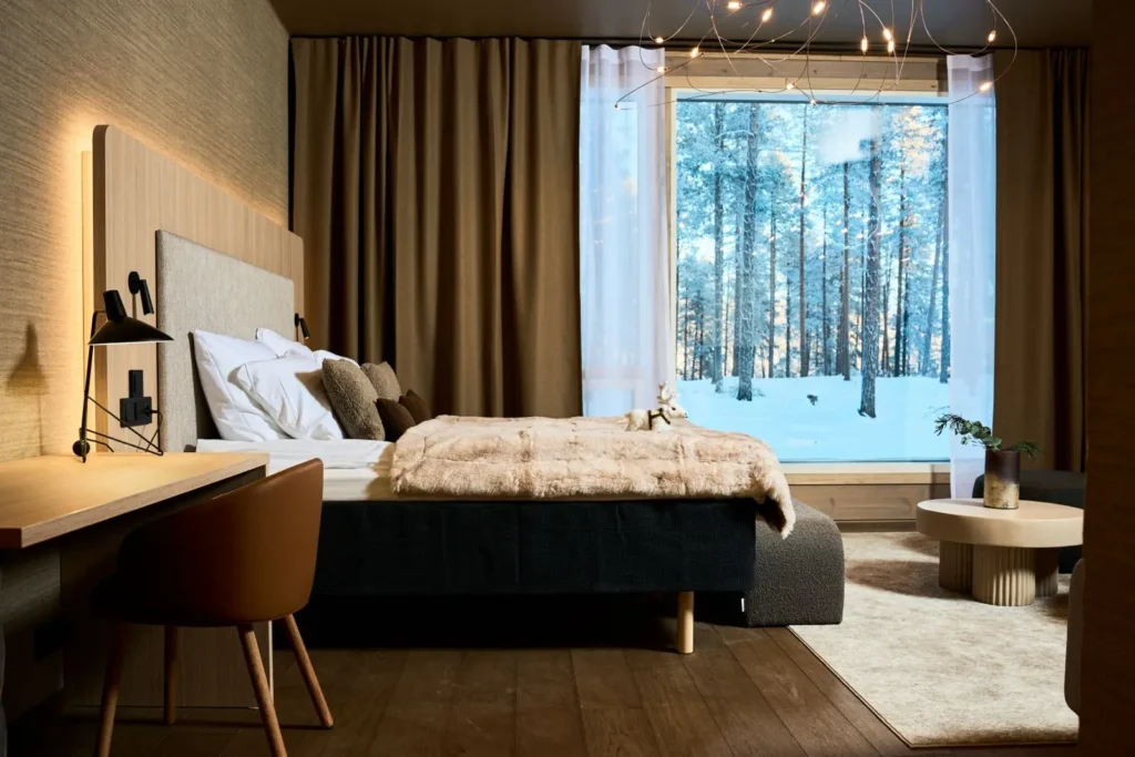 North Star Luxury Suite bedroom with snowy forest view at the five-star Balder Luxury Lodge in Levi, Finnish Lapland